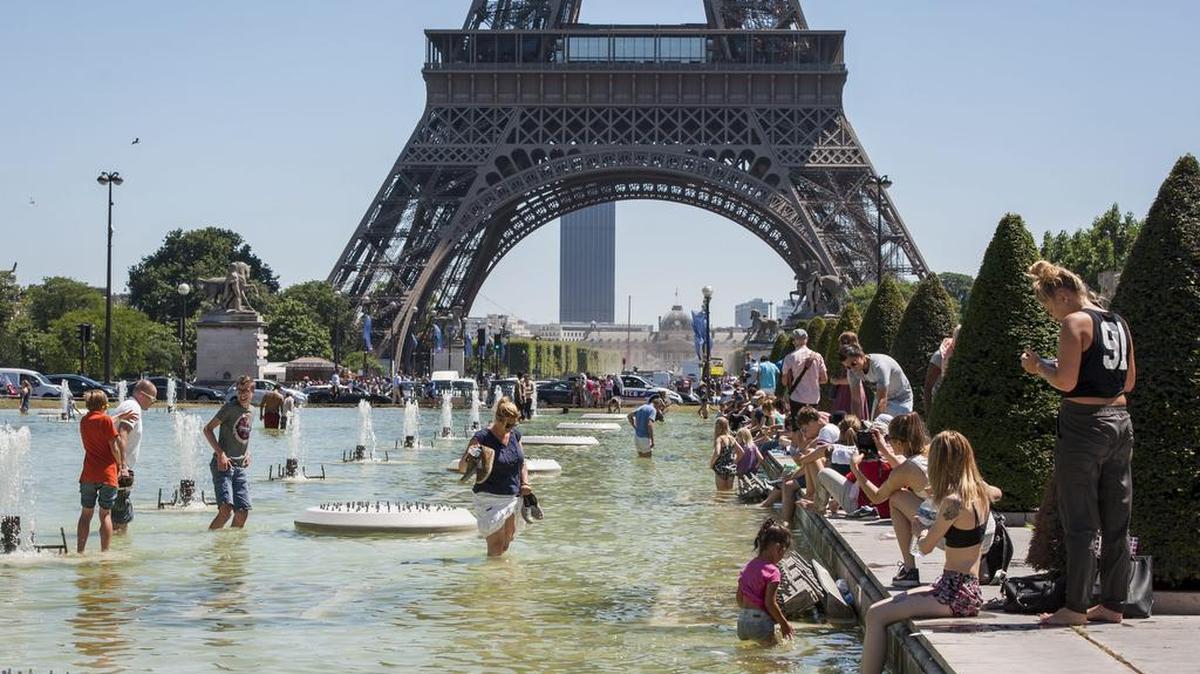 Multitud de personas se refrescan en las fuentes de los jardines del Trocadero junto a la Torre Eiffel en París, Francia, el 19 de julio de 2016. La agencia meteorológica nacional ha aumentado el nivel de alerta por las altas temperaturas en buena parte del país.