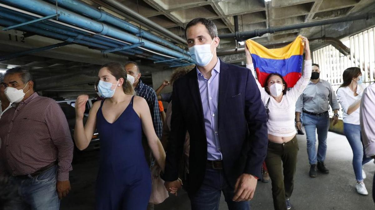 El líder opositor Juan Guaidó y su esposa Fabiana Rosales caminan en el estacionamiento del edificio residencial en el que viven luego de una conferencia de prensa improvisada el lunes 12 de julio de 2021 en Caracas, Venezuela.