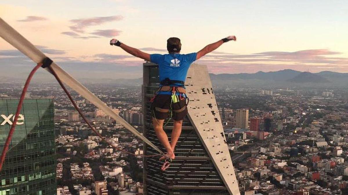 El alemán Alexander Schulz camina el domingo 4 de diciembre de 2016, sobre una cinta sujeta colocado en lo alto de dos edificios corporativos en Ciudad de México y rompió dos marcas de altura y distancia al concretar su recorrido.