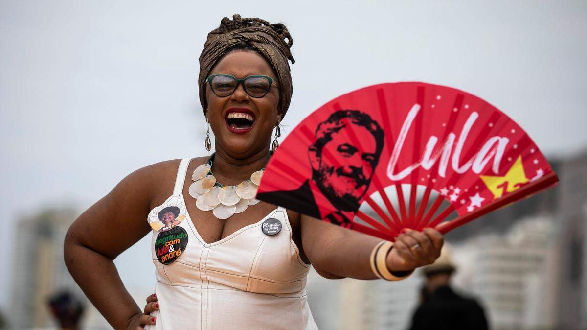 A woman holds a fan with the image of Brazil´s former president Luiz Inacio “Lula” da Silva, who is again running for president, during a Black Women´s March, at Copacabana beach in Rio de Janeiro, Brazil, Sunday, July 31, 2022. Brazil’s general elections are scheduled for Oct. 2, 2022. (AP Photo/Bruna Prado)