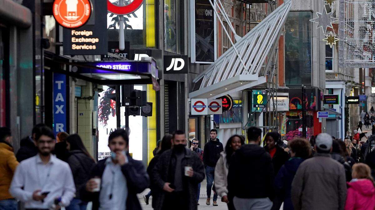 Peatones, algunos usando tapabocas o mascarillas debido a la pandemia del COVID-19, caminan el domingo por la calle Oxford, en la parte central de Londres, en donde se pueden observar varias tiendas cerradas. El gobierno británico ha instaurado una prohibición estricta de no salir a la calle en Navidad debido al impacto de una nueva cepa del coronavirus que esta “fuera de control”.