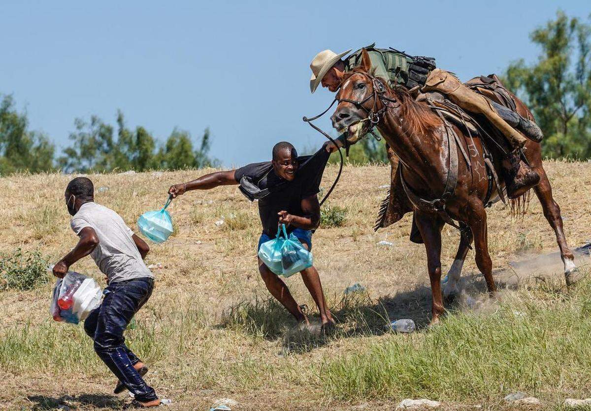 Un agente de la Patrulla Fronteriza de los Estados Unidos a caballo intenta evitar que un migrante haitiano ingrese a un campamento a orillas del Río Grande cerca del Puente Internacional Acuña del Río en Del Río, Texas el 19 de septiembre , 2021. PAUL RATJE / AFP a través de Getty Images)