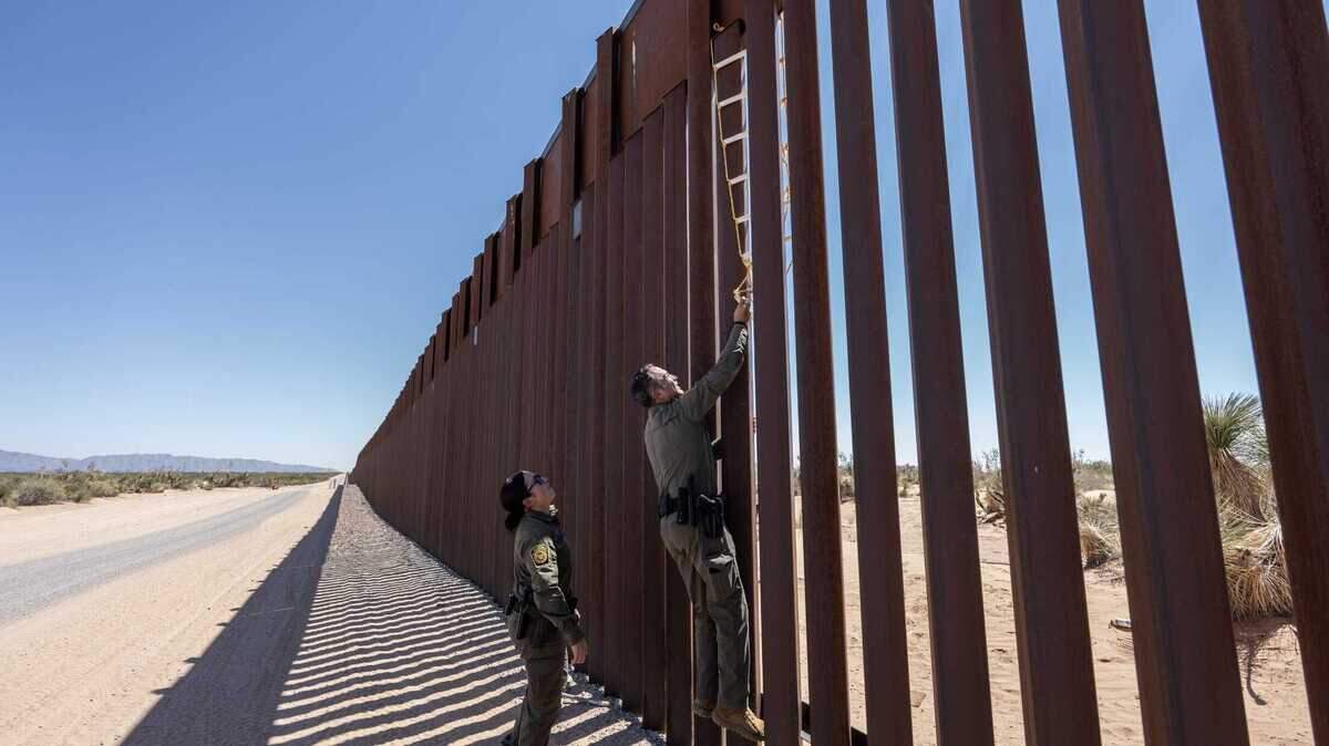 El agente de la Patrulla Fronteriza Claudio Herrera intenta desalojar una escalera casera utilizada por migrantes para escalar el muro fronterizo en el desierto de Santa Teresa, Nuevo México.