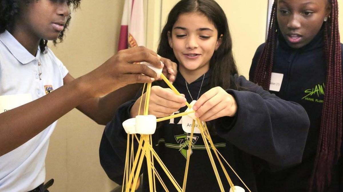 Miembros de Team Oh Yeah Dynasia Jean-Charles, a la izquierda, Araya López y Dumiya Fenelon, todos los 12, construyen una estructura de spaghetti y malvavisco durante una sesión de tecnología el jueves 20 de octubre de 2016 en el Parque de Ciencia y Tecnología de la Vida de la Universidad de Miami.
