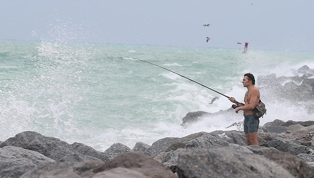 Mike Ritger pesca desde el embarcadero de Government Cut en South Pointe, Miami Beach, desafiando el viento y las olas.