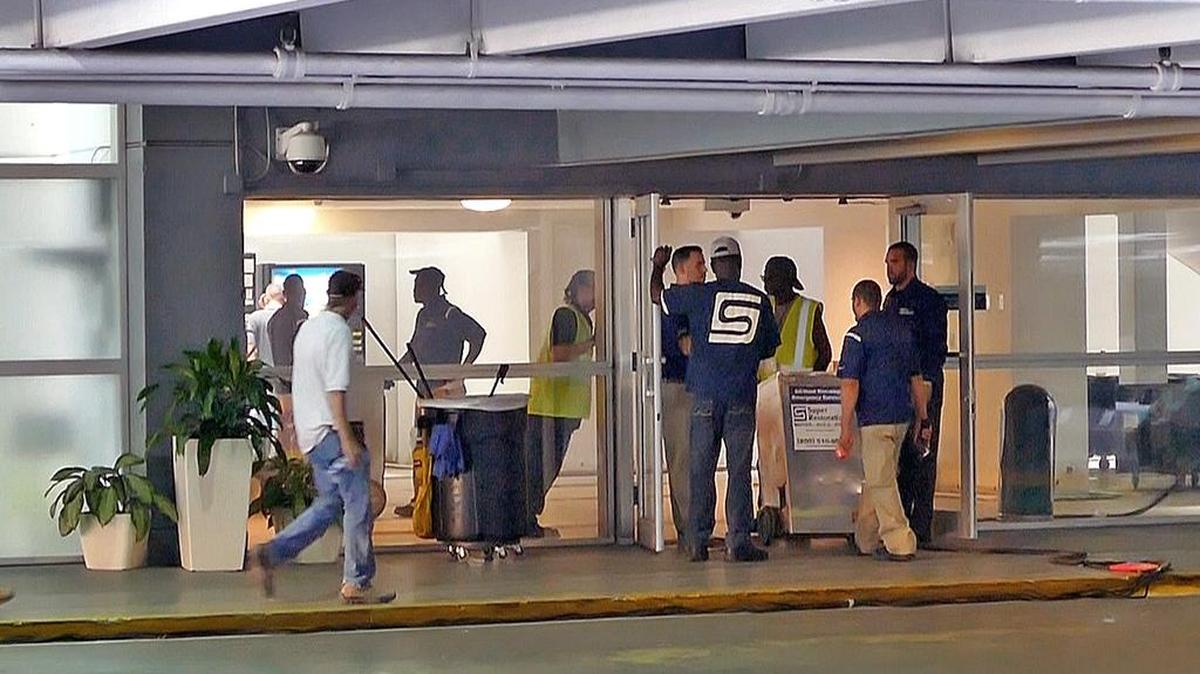 Trabajadores especializados en tratar daños ocasionados por el agua, el fuego y el moho realizan labores en la oficina de Pasaportes de EEUU.