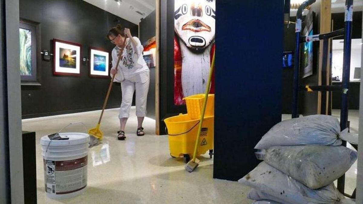 LeeAnn Lough evacua agua de lluvia de la Lincoln Road Gallery de su esposo luego de que fuertes lluvias inundaron Lincoln Road el 1 de agosto. Oficiales de Miami Beach están ofreciendo sacos de arena a los residentes esta semana mientras el huracán Irma amenaza con impactar al sur de la Florida.