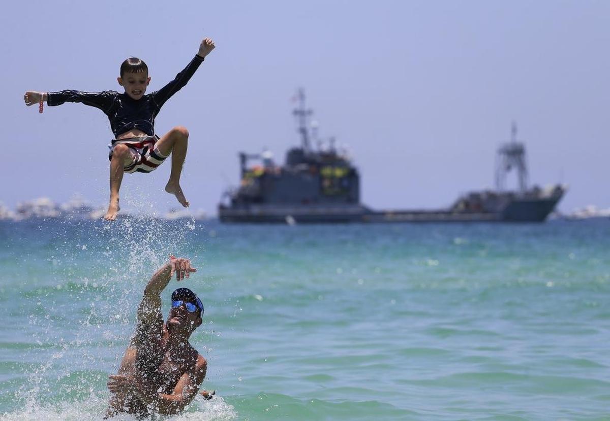 Logan, de seis años, juega con su padre Mike Logan en la playa Lummus Park en Miami Beach.