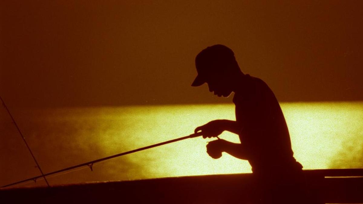 Danny Arcila, de 16 años, pesca al amanecer desde el muelle Newport Fishing Pier, en Sunny Isles Beach.