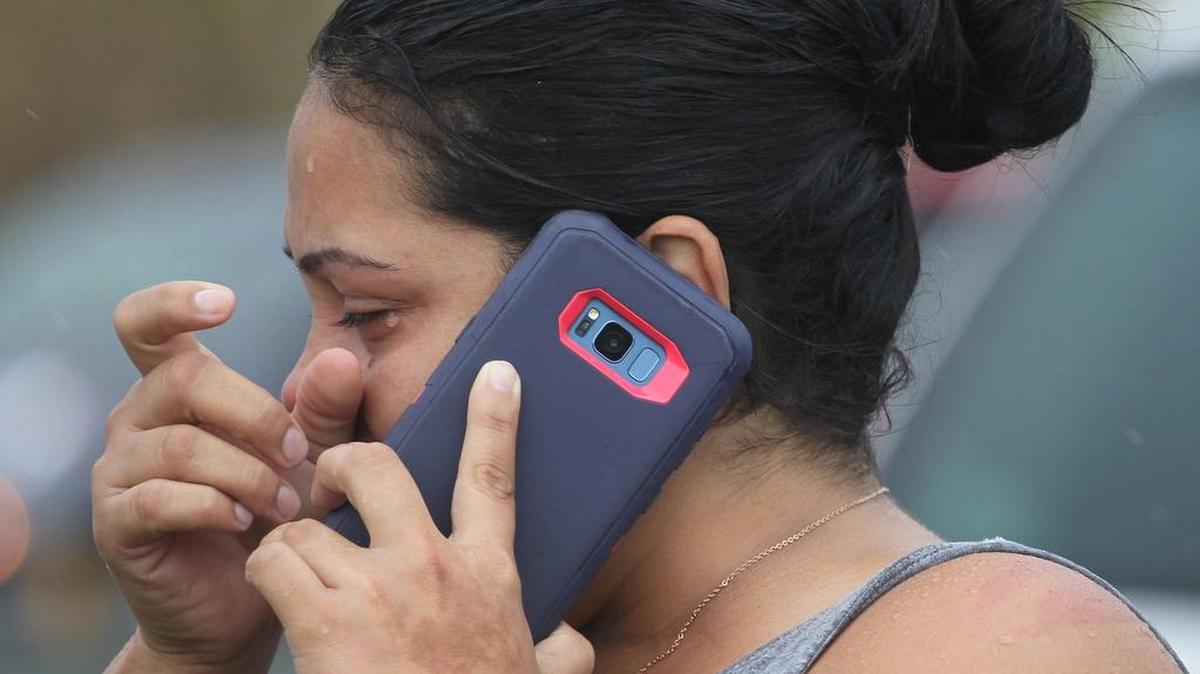 Una mujer no puede contener el llanto cuando finalmente logra contactar a sus familiares en Estados Unidos, el sábado 23 de septiembre de 2018 cerca de el Dorada, en la Autopista PR22 en Puerto Rico.