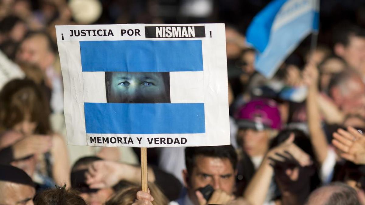 Un hombre sostiene una pancarta con una foto del fiscal Alberto Nisman, durante el primer aniversario de su muerte, en Buenos Aires, Argentina, Lunes, 18 de enero 2016.