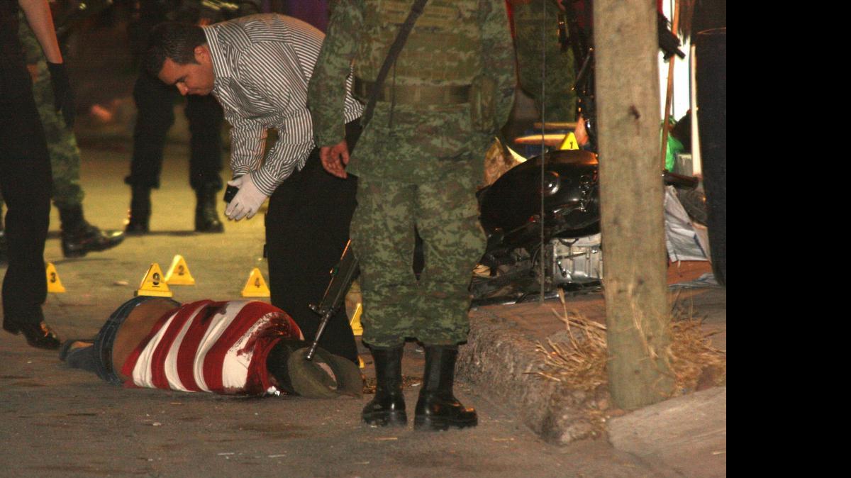 
Un perito forense en la escena donde dos hombres fueron acribillados een el 2011, mientras conducían sus motocicletas, en una colonia popular de Chihuahua, capital del estado del mismo nombre.
