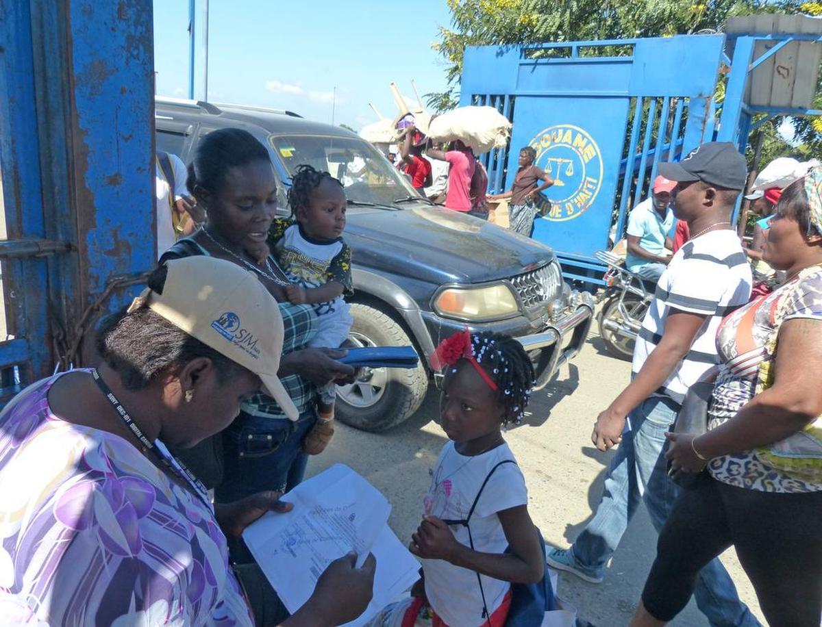 Un trabajador de protección infantil interroga a una madre haitiana en la frontera entre Haití y la República Dominicana.
