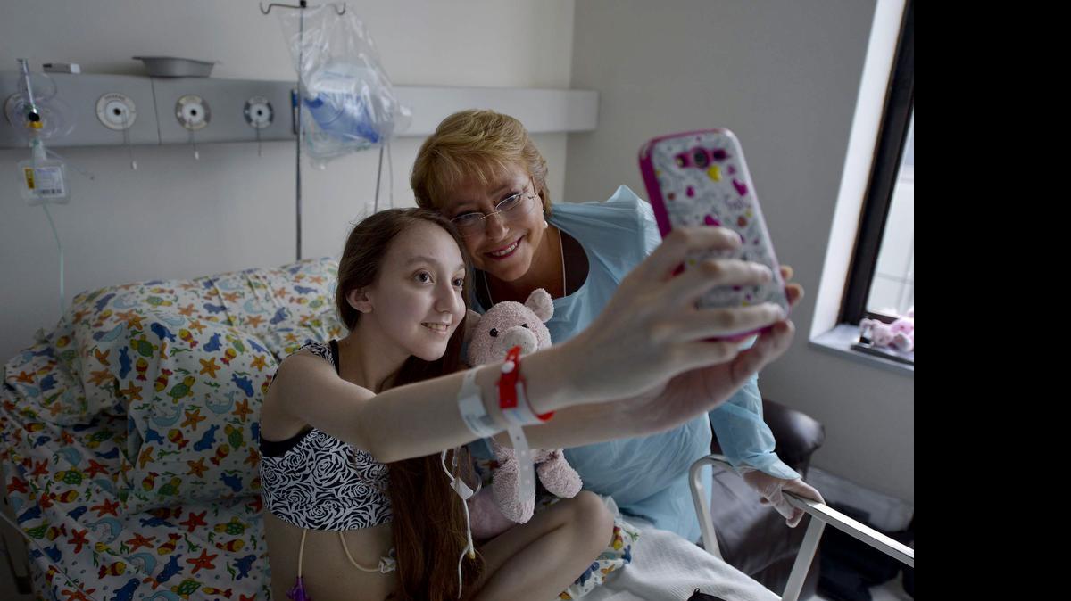 
La presideta chilena Michelle Bachelet posa con la niña Valentina Maureira, en un hospital en Santiago de Chile, el 28 de febrero de 2015. Maureira falleció el jueves debido a complicaciones en su afección respiratoria.

