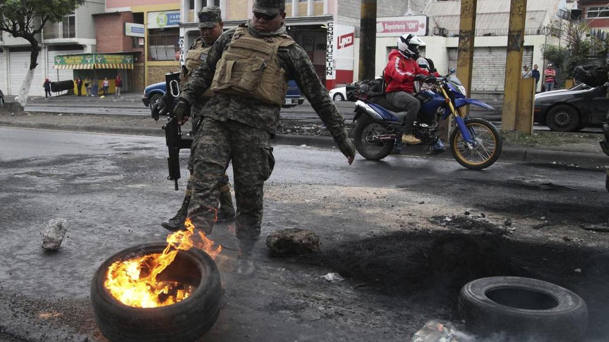 La Policía militar quita una barricada de protesta en Tegucigalpa, Honduras, el lunes 18 de diciembre.