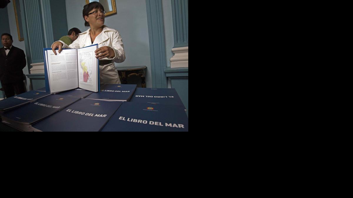 
Una funcionaria de la Cancillería boliviana muestra el texto boliviano que se distribuye este domingo en las 10 principales ciudades del país, durante un acto en La Paz. 
