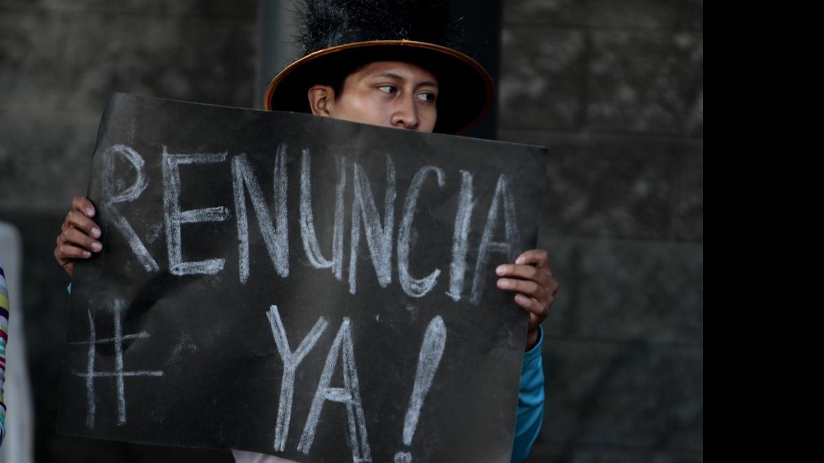 
Un integrante del movimiento ‘#HagamosElParo o nos saldrá más caro’ muestra un cartel pidiendo la renuncia del presidente de Guatemala, Otto Pérez Molina, mientras realizaban una el martes Ciudad de Guatemala.
