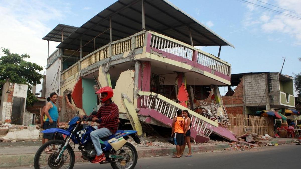 Habitantes pasan el viernes frente a una vivienda averiada por el terremoto en Manta, Ecuador.