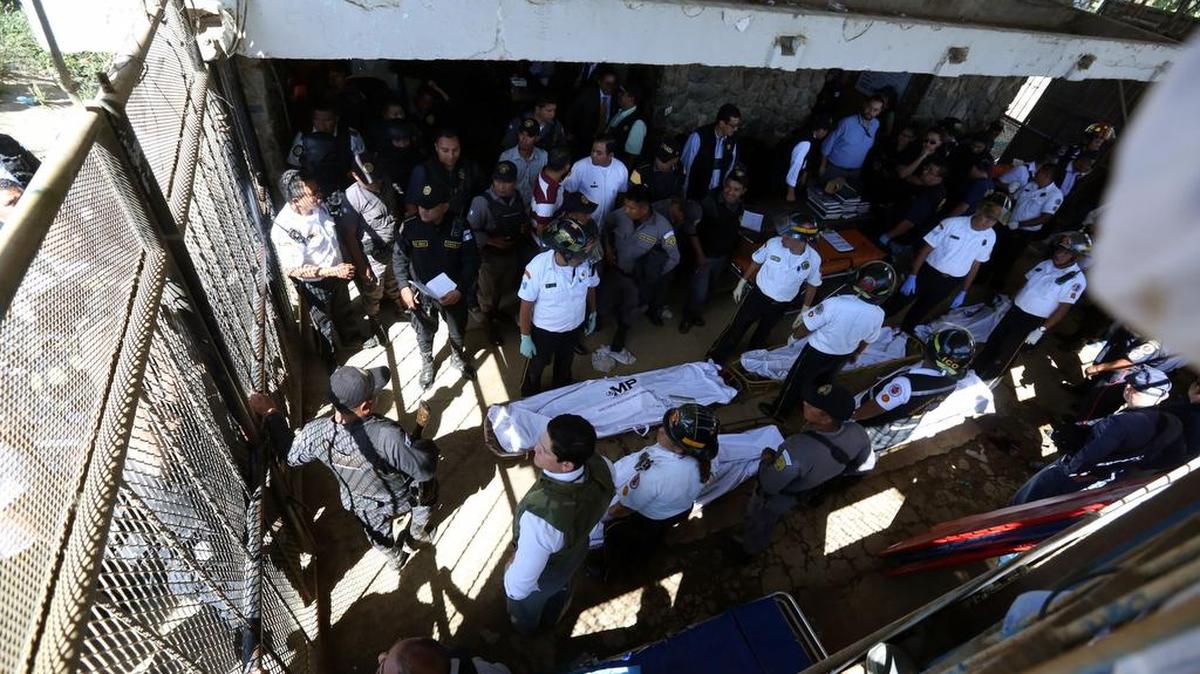 Guardias del Sistema Penitenciario de Guatemala junto a los cuerpos de las víctimas asesinadas el lunes, en la cárcel Granja Penal Pavón en Fraijanes.