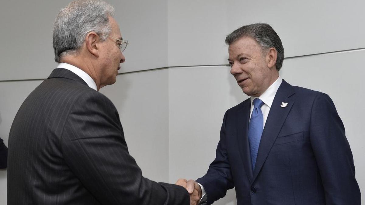 El mandatario Juan Manuel Santos (der.), saluda al ex presidente de Colombia Álvaro Uribe Vélez (izq.) el miércoles en Bogotá.