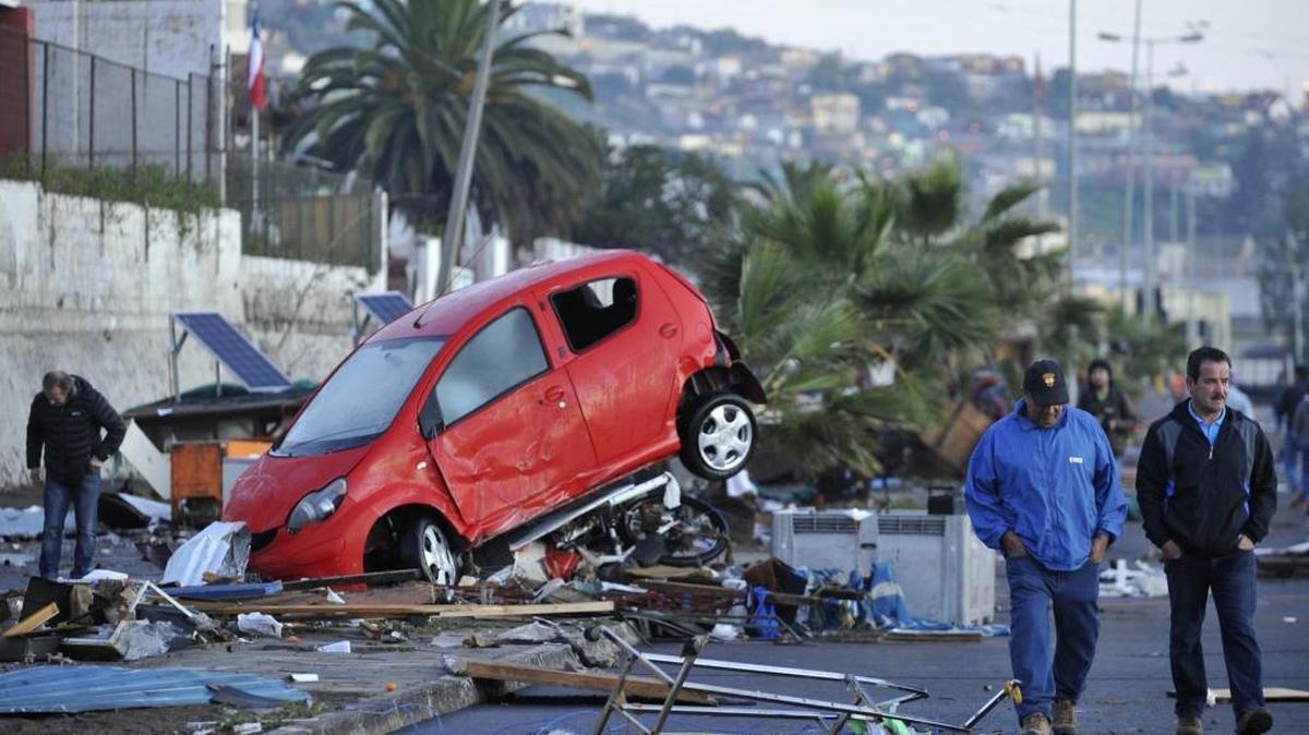 
Dos hombres caminan frente a un vehículo arrastrado por el tsunami posterior al terremoto 8,4 en la escala de Richter que anoche sufrió Chile, en la localidad costera de Cquimbo (Chile).
