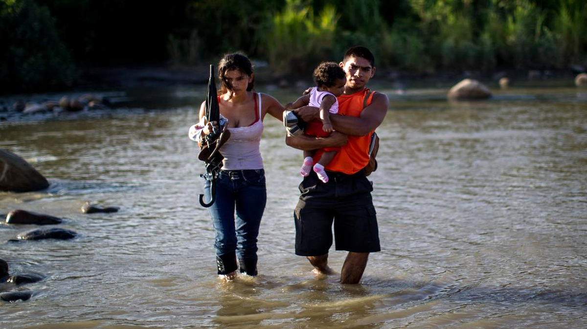
Una familia cruza el río Táchira, que divide a Venezuela y Colombia, hoy, sábado 29 de agosto de 2015, en el sector "La Invasión", en la ciudad de San Antonio (Venezuela). 

