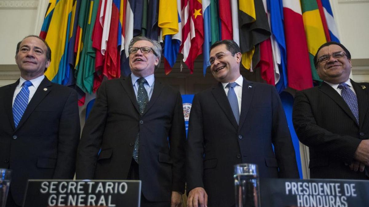 El secretario general de la Organización de Estados Americanos (OEA), Luis Almagro y el presidente de Honduras, Juan Orlando Hernández (c-d), posan durante la ceremonia de firma del convenio de la Misión de Apoyo Contra la Corrupción y la Impunidad en Honduras (Maccih) el 19 de enero de 2016.