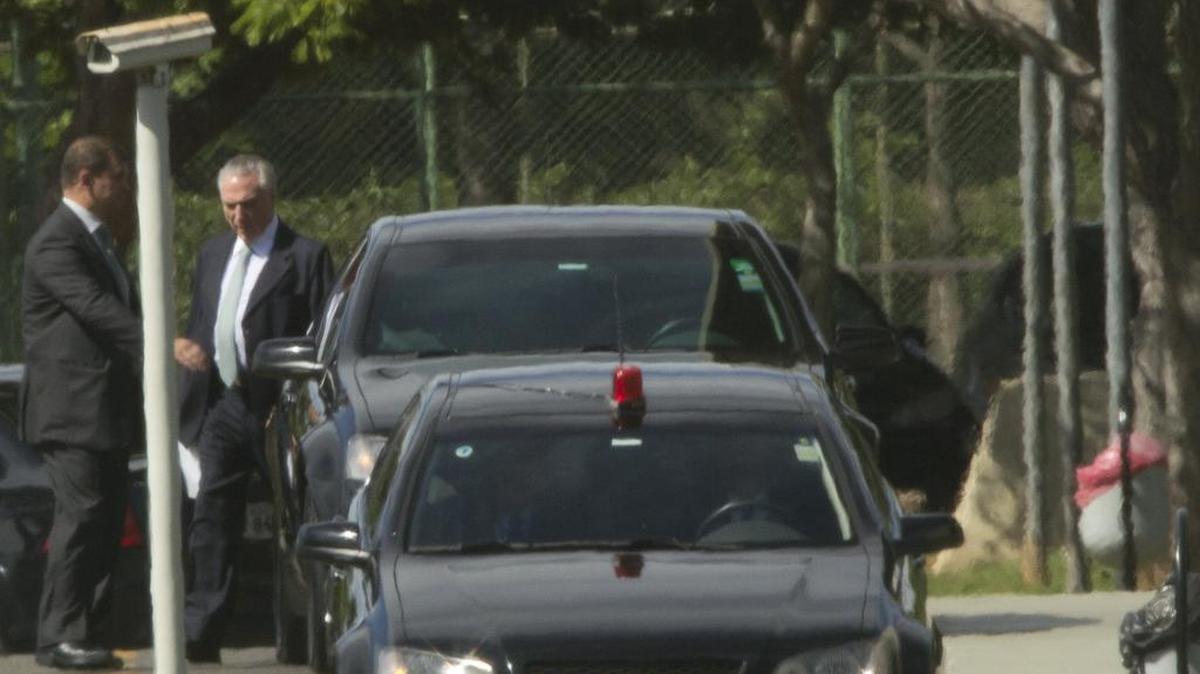 El presidente de Brasil, Michel Temer (d), sale acompañado de un miembro de la seguridad el martes 23 de mayo de 2017, en la residencia oficial del Palacio del Jaburu en Brasilia (Brasil).