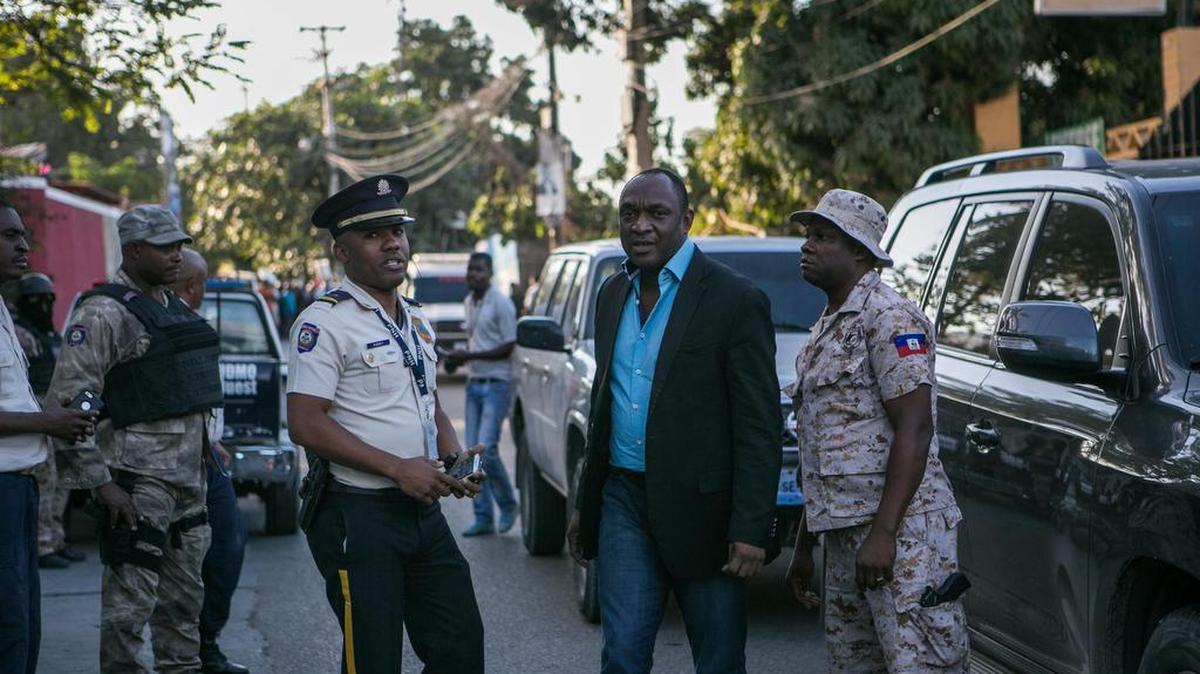 El senador Youri Latortue (c), llega al lugar donde fue arrestado minutos antes el senador electo Guy Philipe el jueves 5 de enero de 2017, en Puerto Príncipe (Haití). Philipe, sobre quien pesa una orden de captura de la agencia antidrogas de Estados Unidos (DEA), fue arrestado por agentes de la Policía Nacional Haitiana cuando salía de una estación radial en la zona capitalina de Petionville.