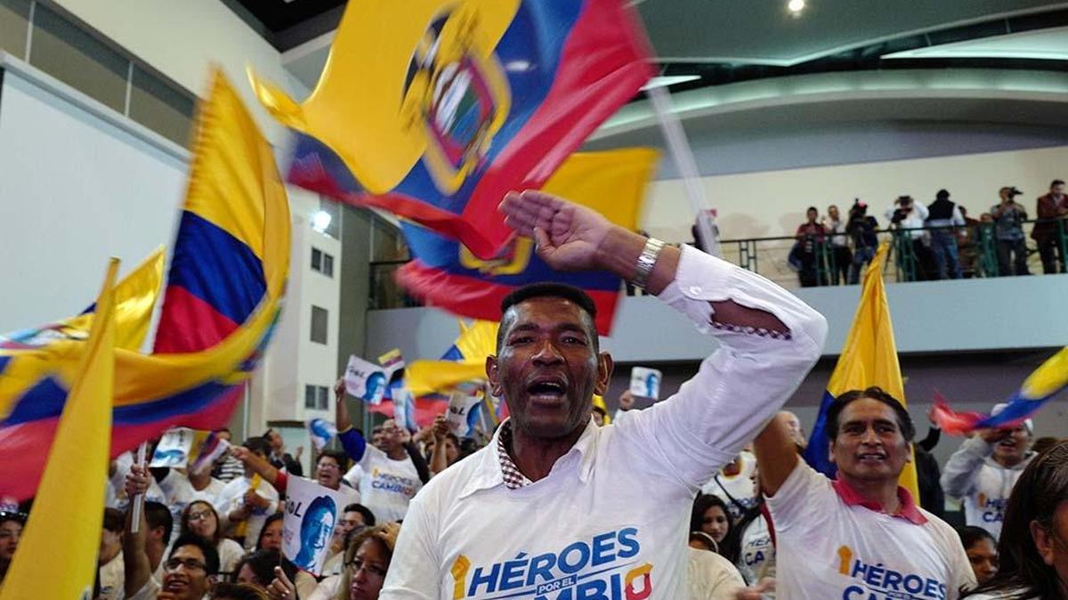 Víctor Torres sostiene una bandera ecuatoriana durante un acto de campaña del candidato opositor Guillermo Lasso, en Quito este martes.
