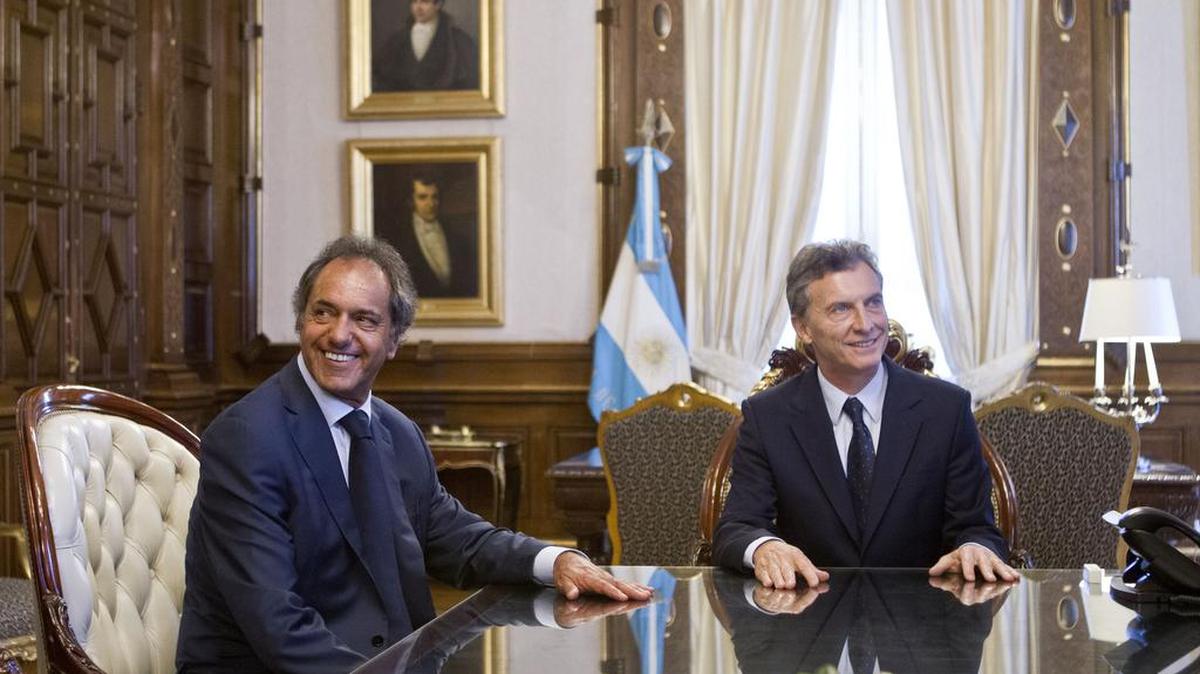 El presidente de Argentina Mauricio Macri (der.) habla el viernes con su rival en la carrera presidencial el peronista Daniel Scioli en su primera reunión con dirigentes de la oposición, en la Casa Rosada en Buenos Aires.
