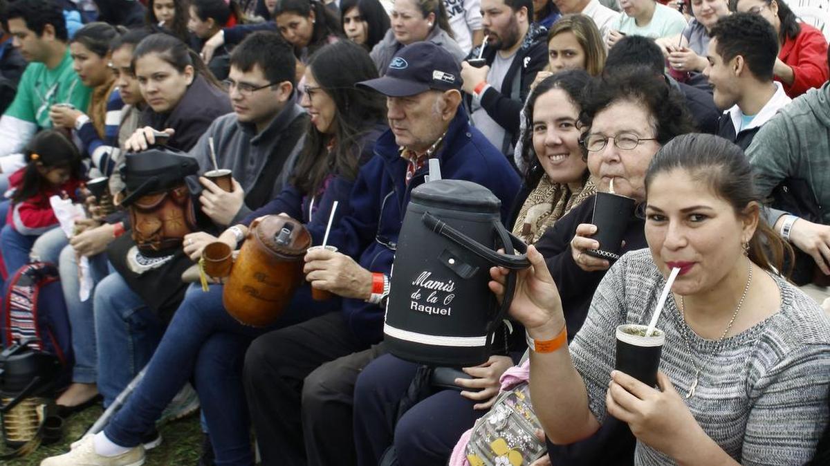 Las personas beben 'tereré' (infusión paraguaya de yerba mate y agua fría) en Asunción para romper el récord mundial de Guinness en la ronda más grande 'terere' del mundo, el 14 de octubre de 2017.