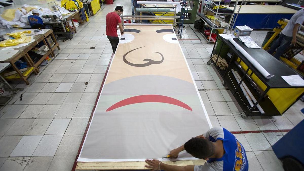 Operarios trabajan en la producción del Pixuleco gigante.