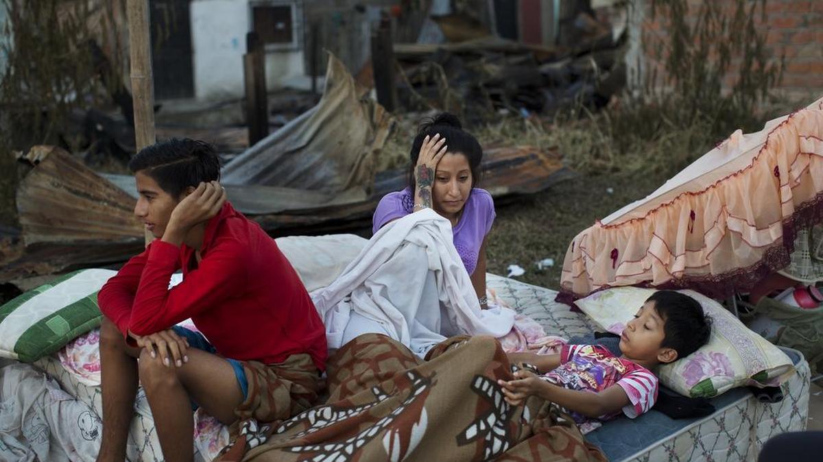 Una familia despierta después de dormir fuera de su casa derrumbada, destruida por un terremoto en Manta, Ecuador, el martes, 19 de abril de 2016.