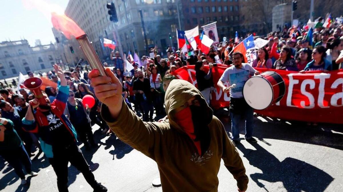 Personas participan en una manifestación para exigir el fin del sistema privado de pensiones impuesto en 1981 por la dictadura de Augusto Pinochet, el domingo 21 de agosto de 2016, en Santiago de Chile (Chile).