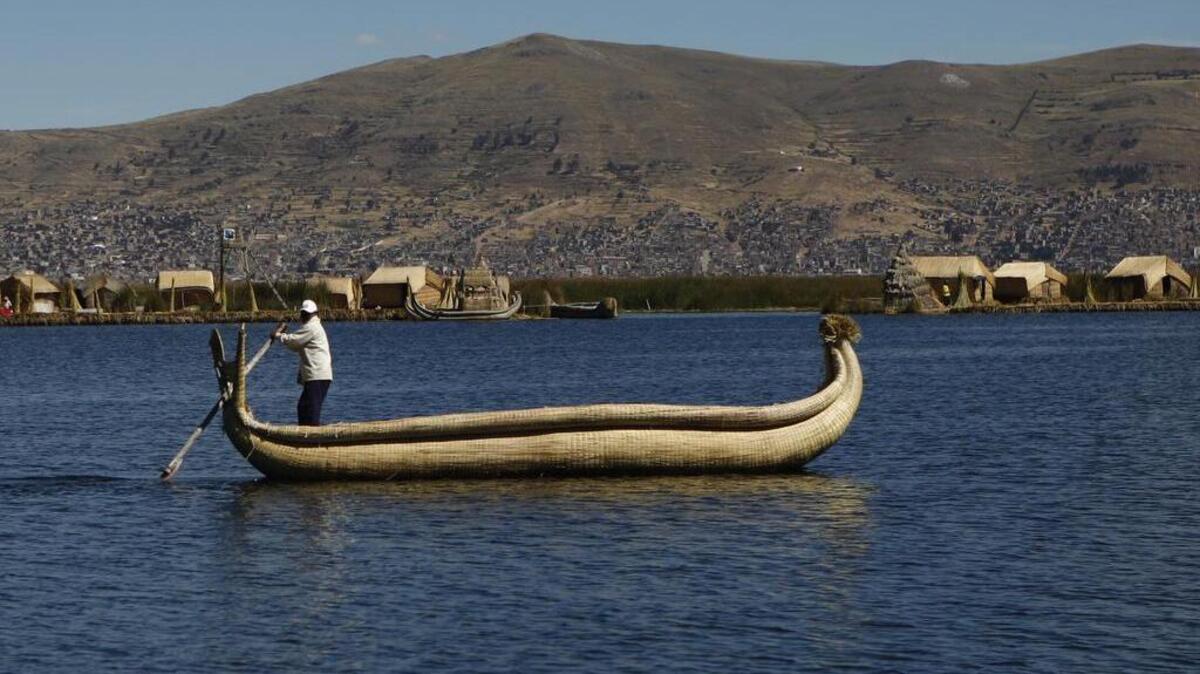 A hombre navega por una de las islas flotantes del Lago Titicaca en la región Puno, Perú, donde habita la ancestral etnia de los uros.