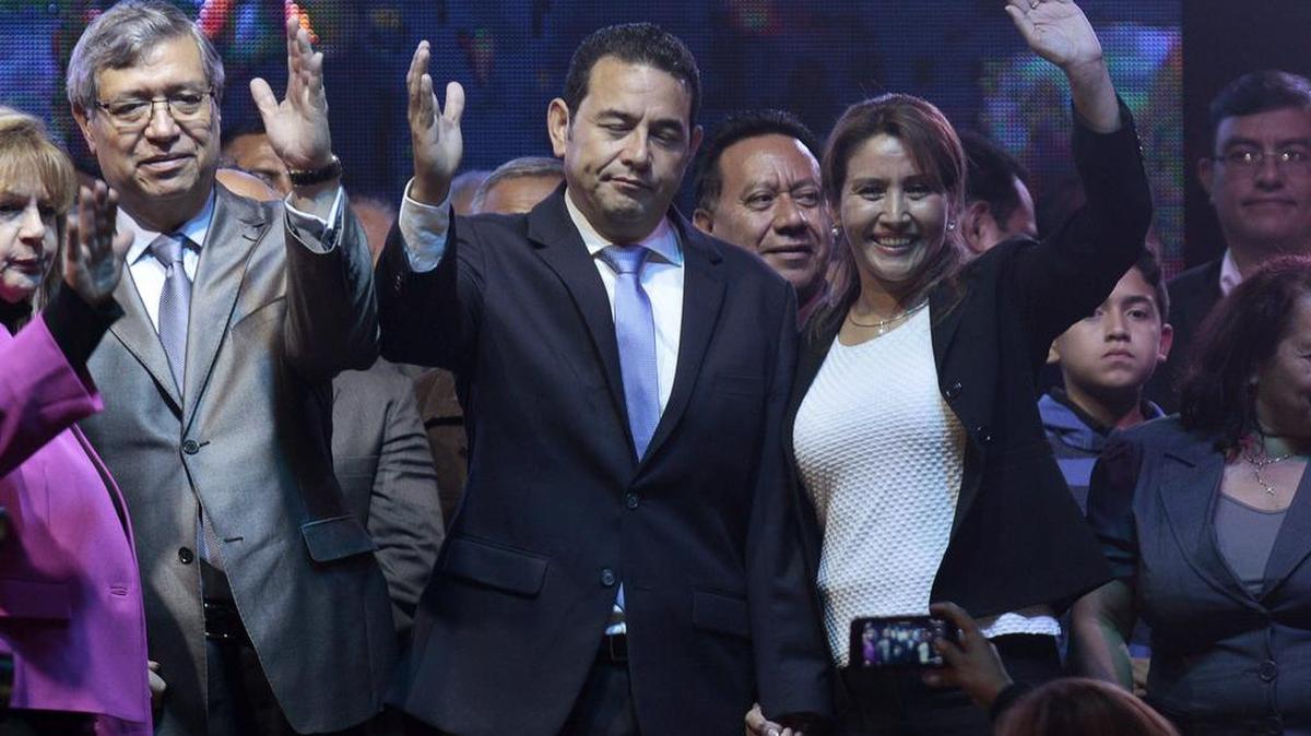 El presidente electo Jimmy Morales (c) del partido Frente de Convergencia Nacional (FCN) celebra tras ganar las elecciones presidenciales en Guatemala, derrotando a Sandra Torres del partido Unión Nacional de la Esperanza (UNE), celebra junto a su vicepresidente Jafeth Cabrera (i) y su esposa Gilda de Morales (d) hoy lunes 26 de octubre de 2015.
