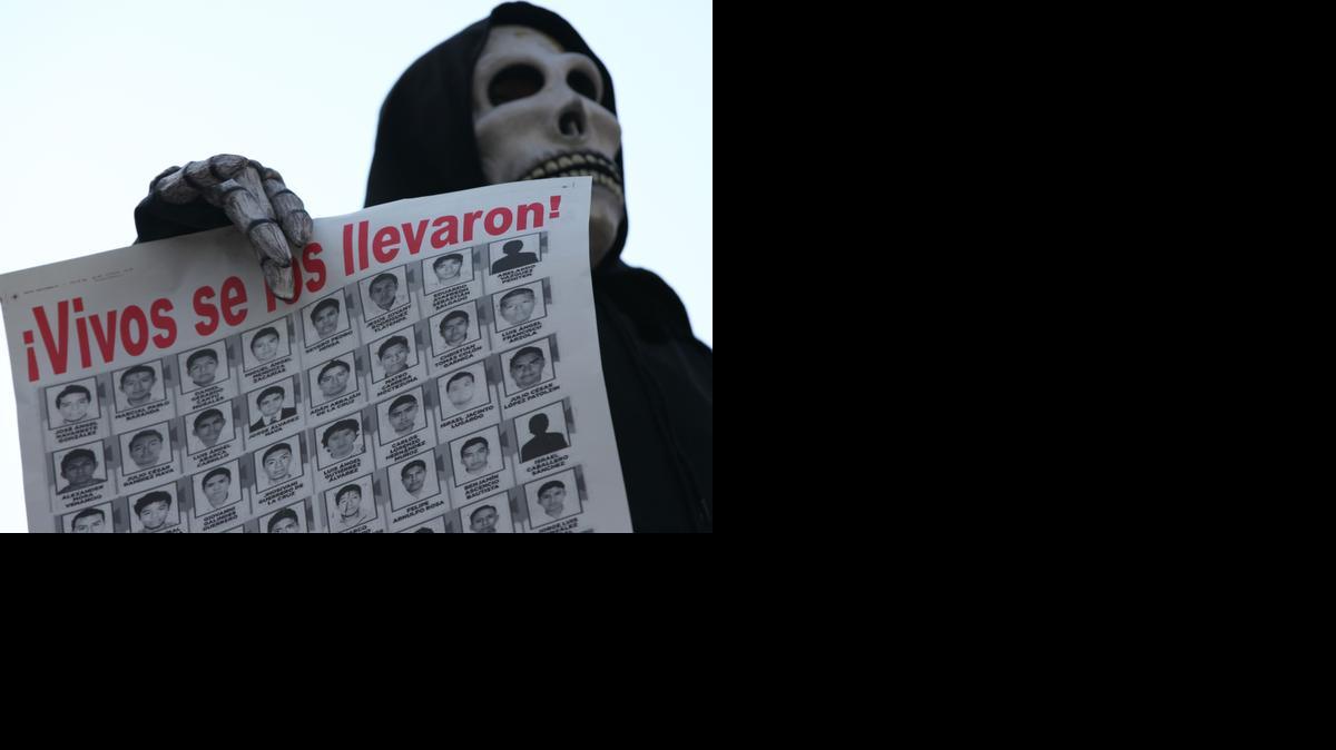 
Un hombre disfrazado de la muerte porta un cartel con las fotos de los 43 estudiantes desaparecidos en septiembre pasado, en el estado de Guerrero.
