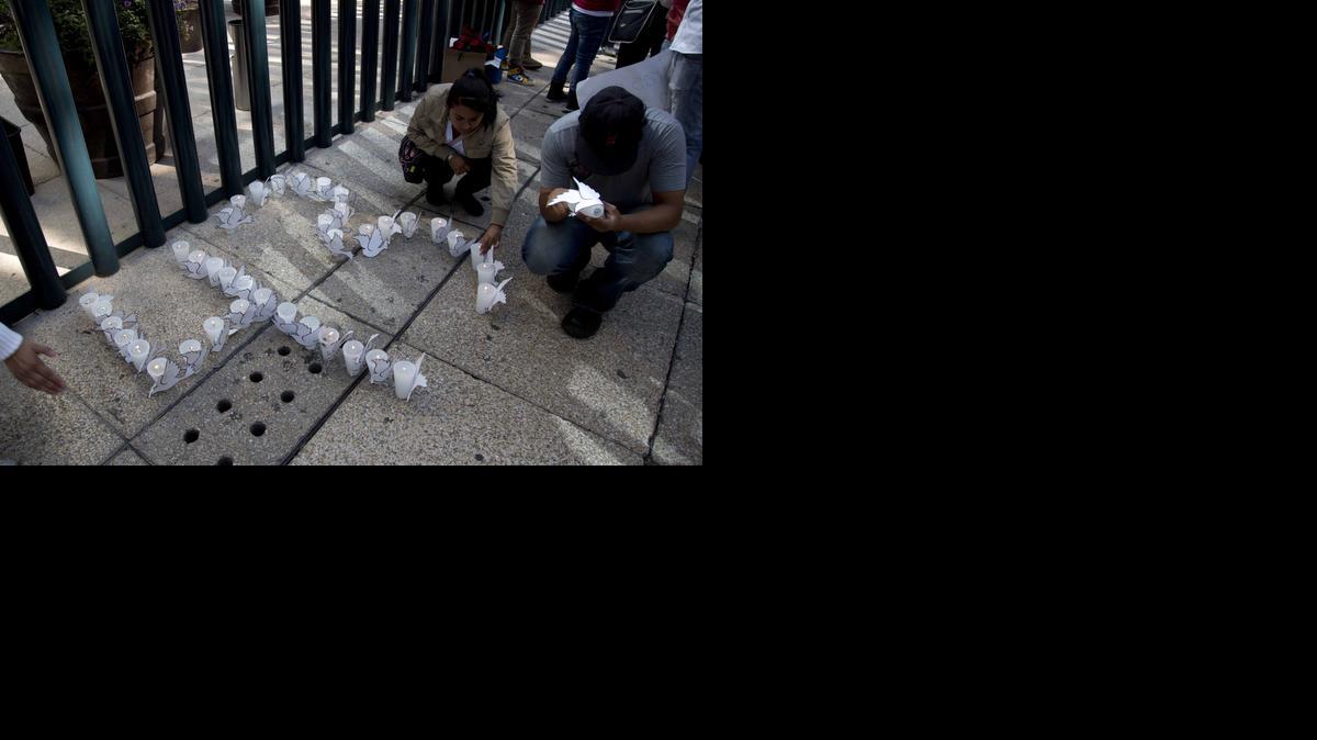 
Estudiantes colocan velas para formar el número de estudiantes desaparecidos en Igual, México, desde el 26 de septiembre, durante un evento frente a la Fiscalía General,el miércoles. 
