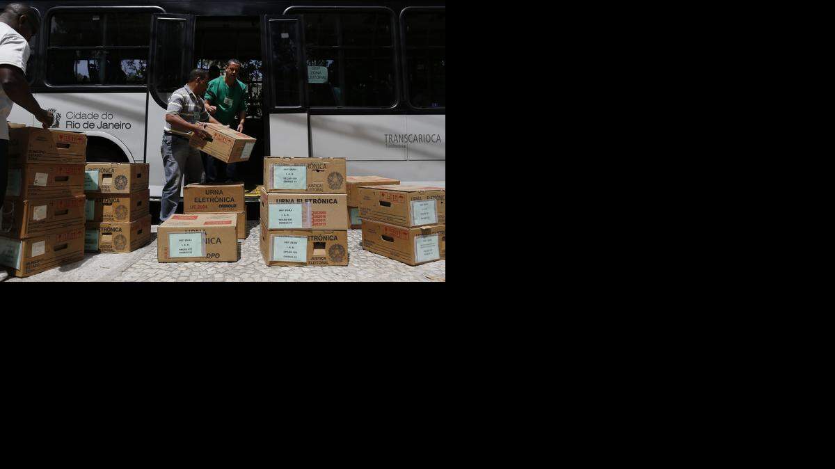 
Trabajadores de elecciones trasladan cajas de material electoral el sábado para preparar un centro de votación en Río de Janeiro.
