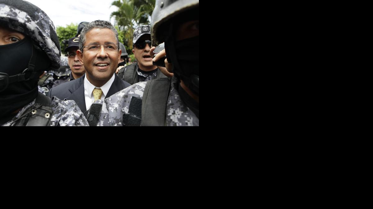 
El expresidente salvadoreño Francisco Flores (cent.) es custodiado durante su salida del centro judicial Isidro Menéndez en San Salvador, El Salvador. 
