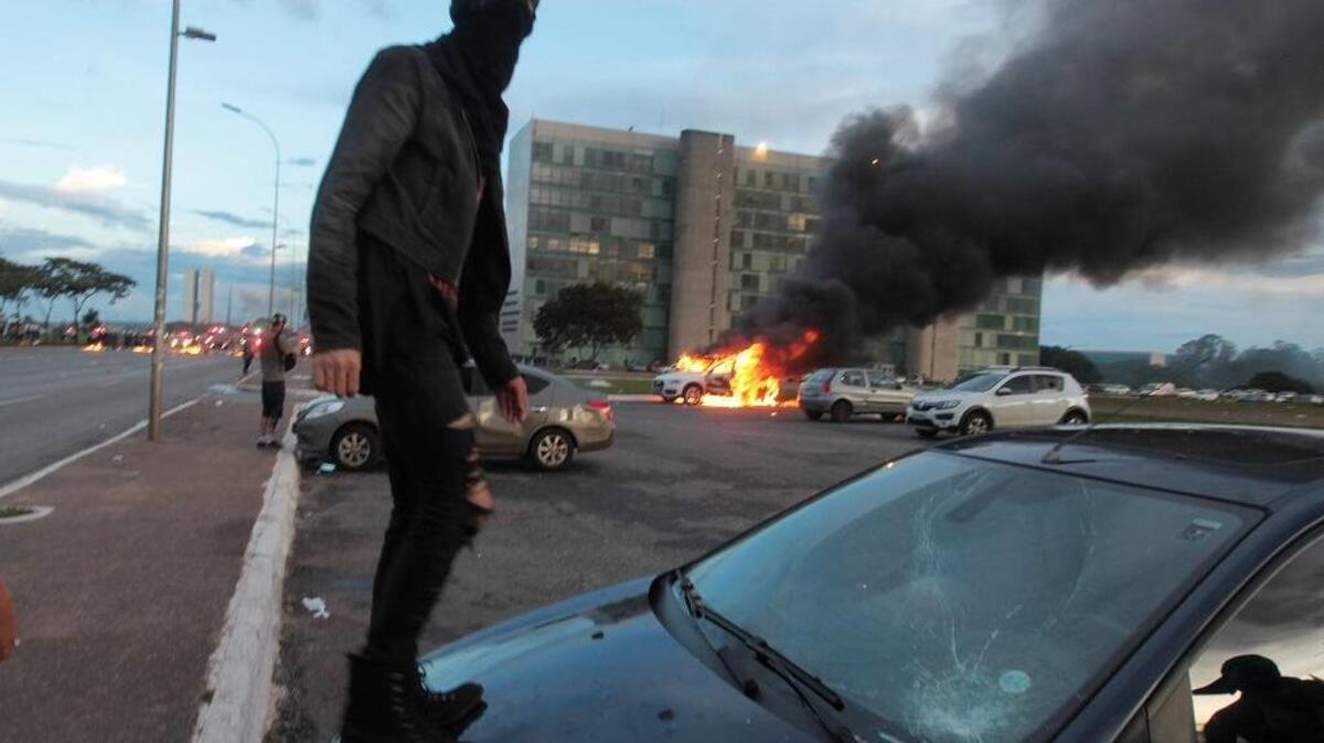 Un manifestante se sube a un vehículo durante una protesta frente al Congreso brasileño contra el ajuste fiscal que promueve el gobierno del presidente Michel Temer y por maniobras que puedan llevar a amnistiar a los culpables de corrupción en Brasilia. La manifestación fue convocada por movimientos estudiantiles y sindicatos en coincidencia con la votación de algunas medidas de ese ajuste fiscal en el Senado y de un paquete de nuevas iniciativas contra la corrupción en la Cámara de Diputados.
