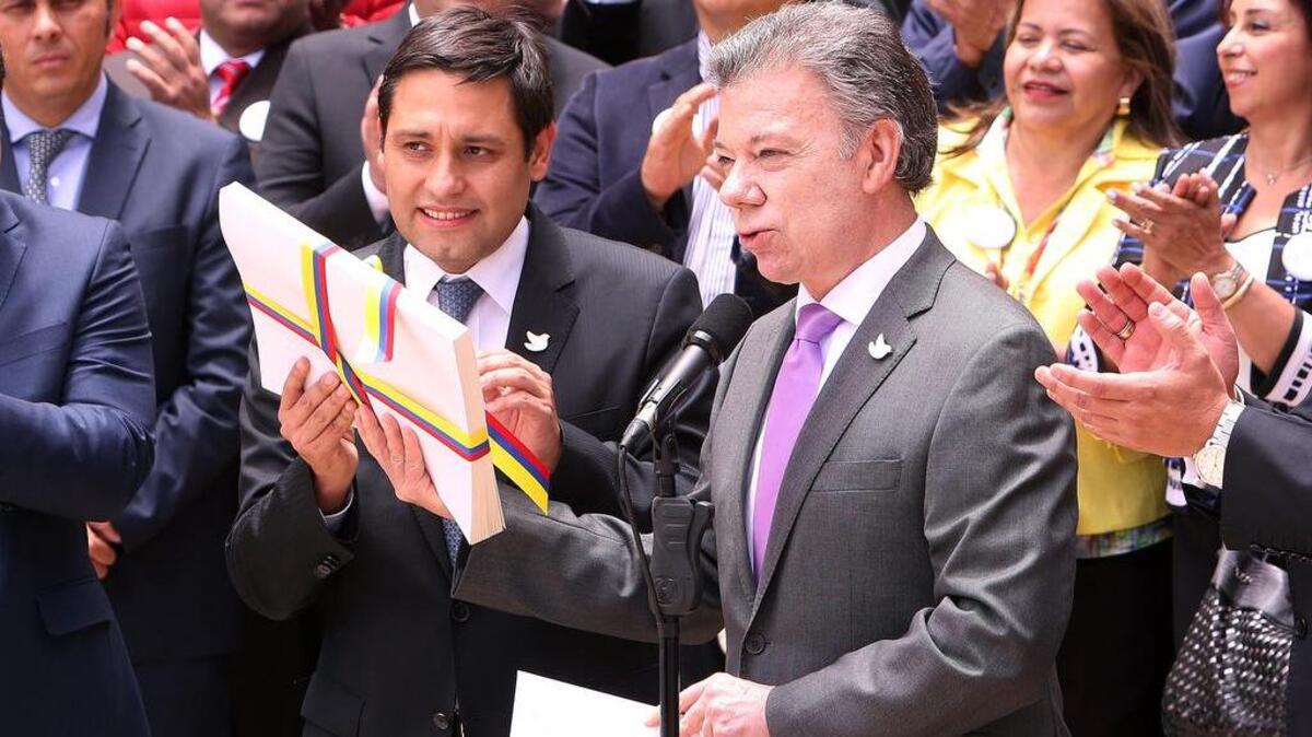 El Presidente de Colombia, Juan Manuel Santos (der.), entrega al presidente del Congreso de Colombia, Mauricio Lizcano (c), el texto definitivo del acuerdo de paz con la guerrilla de las FARC, como paso previo para la convocatoria del plebiscito del 2 de octubre.