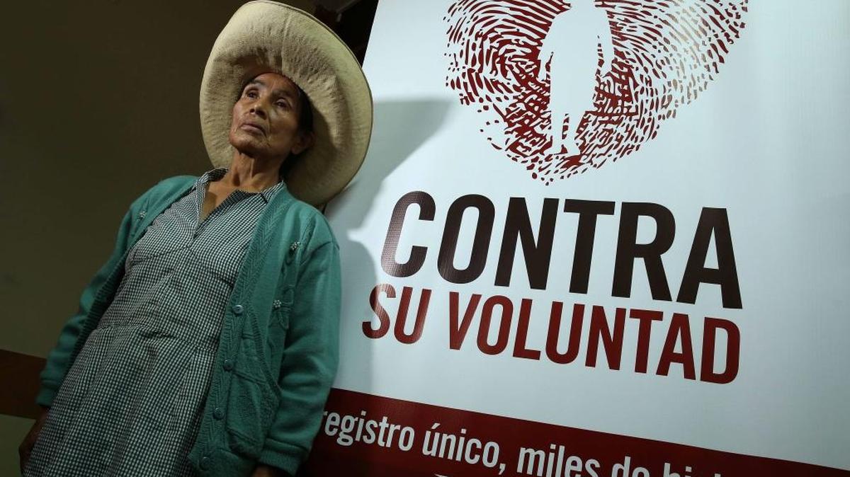 Esperanza Huamaya, víctima de las esterilizaciones forzadas en la localidad de Huancabamba, norte del Perú, posa junto a un afiche promocional el miércoles en Lima, Perú.