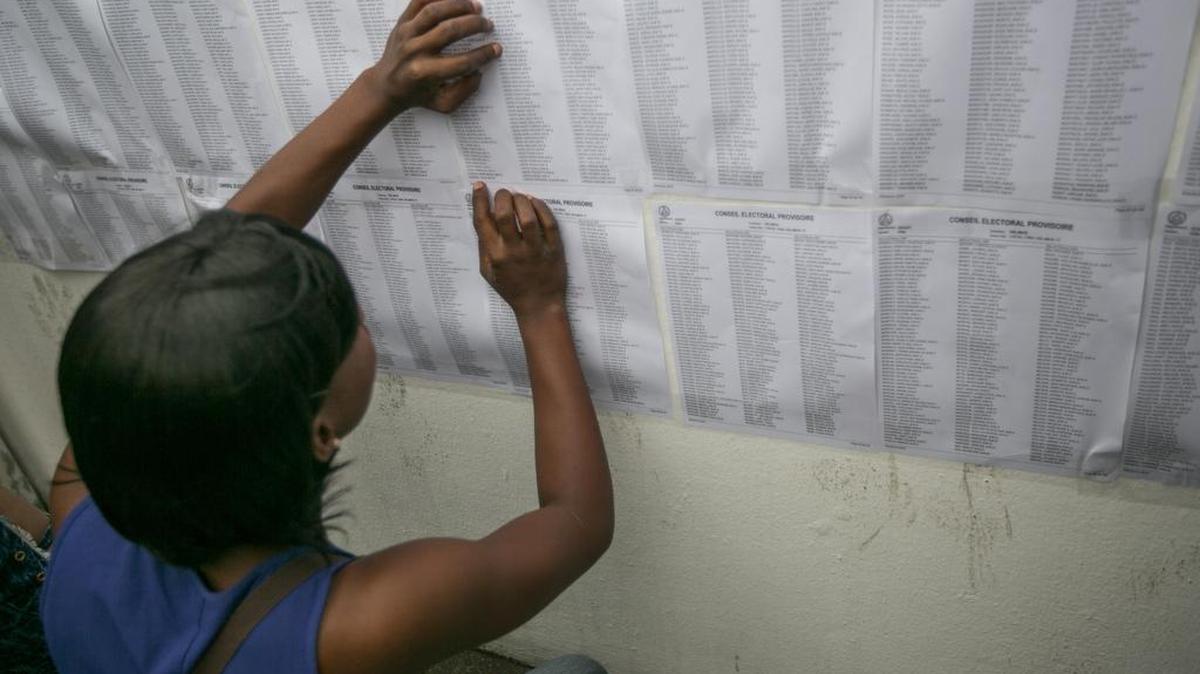 Una mujer busca su nombre en las listas antes de ejercer su derecho al voto el 20 de noviembre de 2016, durante los comicios generales en el país, en Puerto Príncipe.