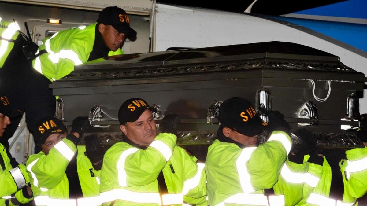 Agentes policiales de Costa Rica trasladan un ataud con el cuerpo de una de las víctimas del naufragio, al llegar al aeropuerto de Juan Santa María, el domingo.