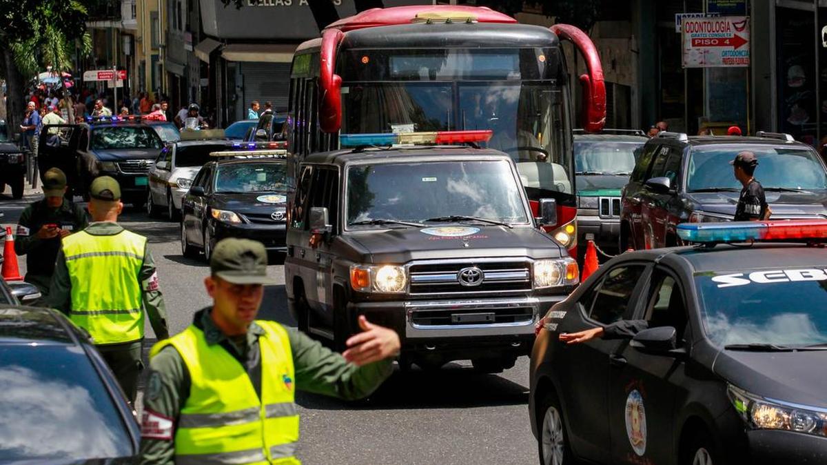 Agentes resguardan el autobús donde trasladan un grupo de presos políticos desde la sede del Servicio Bolivariano de Inteligencia (Sebin) a la Cancillería venezolana.
