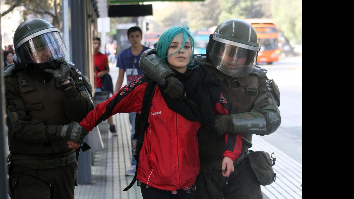 <cutline_leadin>Una estudiante </cutline_leadin>chilena es detenida por la policía el jueves en Santiago de Chile durante una protesta en la cual miles de universitarios exigieron educación gratuita y de calidad.<252><252>