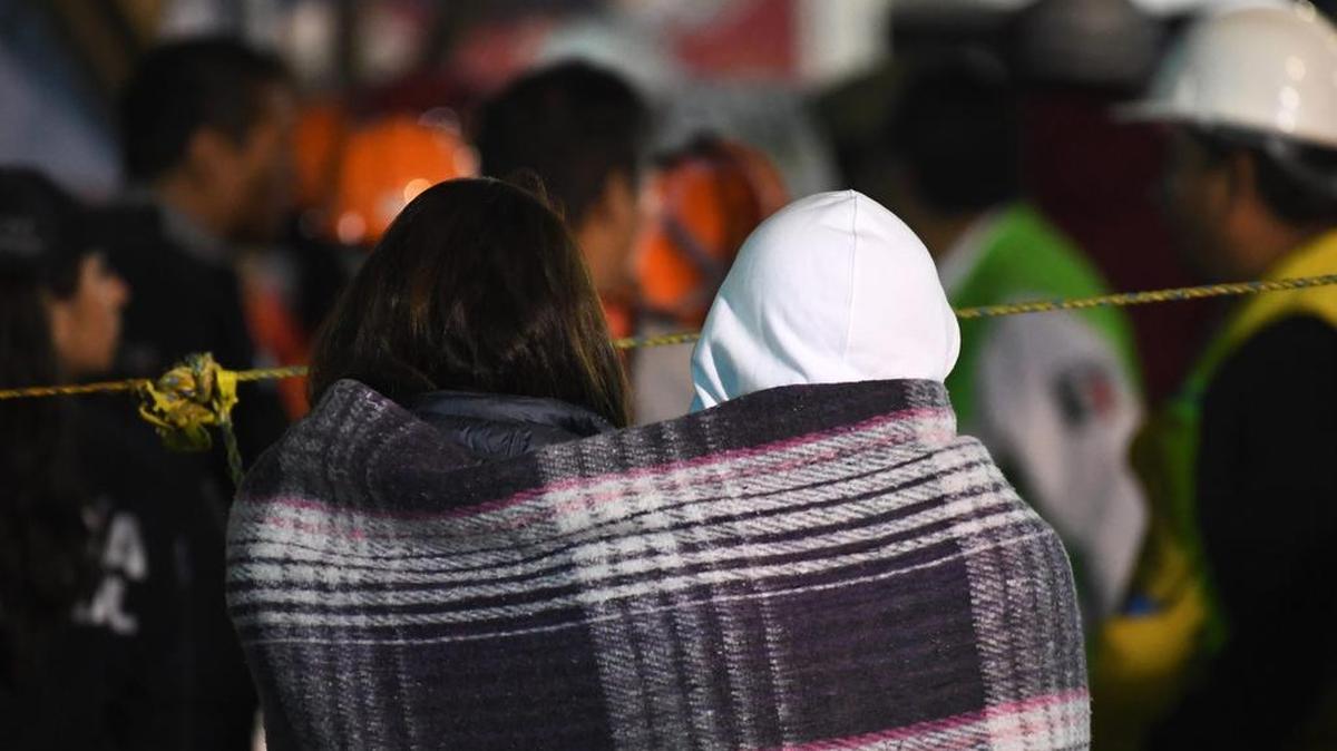 Familiares de una presunta víctima del terremoto observan cómo los rescatistas excavan entre los escombros de un edificio en busca de sobrevivientes en la Ciudad de México el 22 de septiembre de 2017.