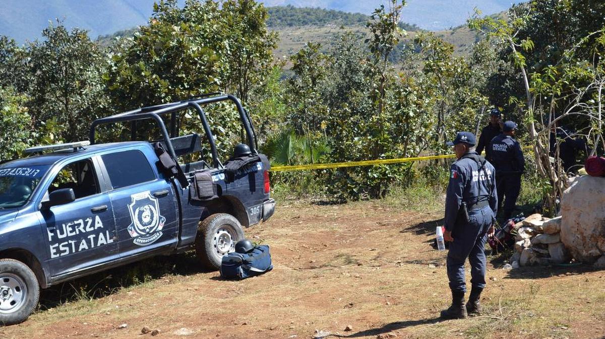 Policías de la Fuerza Estatal resguardan el jueves 24 de noviembre de 2016, el sitio donde peritos forenses trabajan sobre el hallazgo de unas 20 fosas clandestinas, en el municipio de Zitlala del estado mexicano de Guerrero.